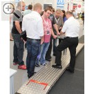 Wessels + Müller Werkstattmesse 2014 FMO Jrg Passoke mit Kunden an der autop Masterlift 2.35 Combi Check-in Hebebhne mit besonders flachen Fahrschienen fr ein gutes Befahren in der Annahme.  